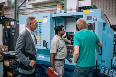 Researchers at McMaster Manufacturing Research Institute in front of equipment