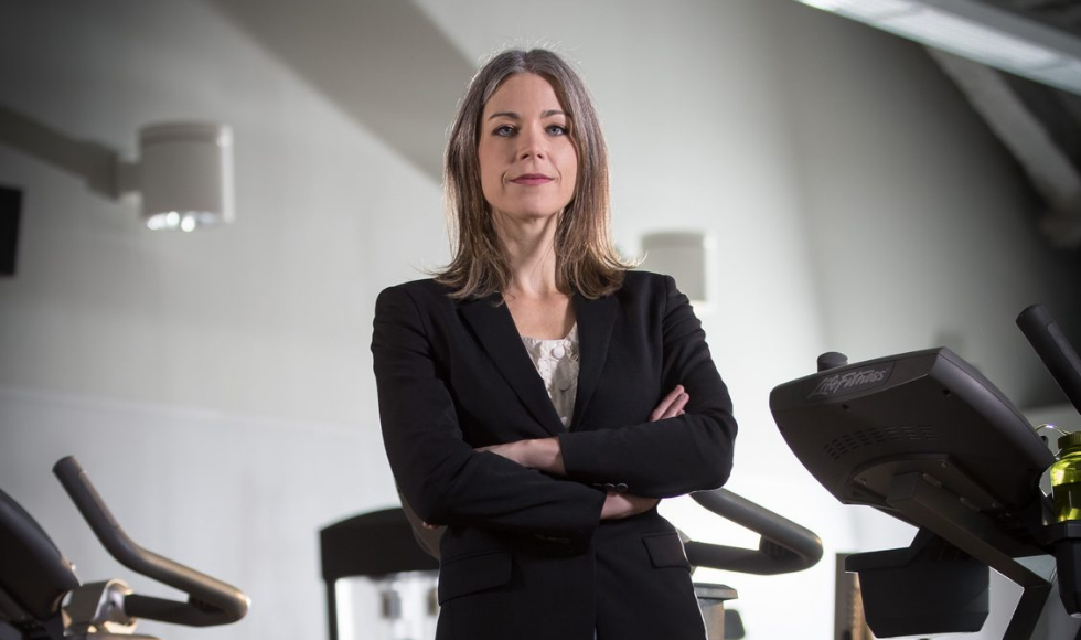 Jennifer Heisz looks at the camera while standing in a gym