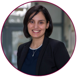 A headshot of Zeinab Hosseinidoust. She is wearing a navy blue shirt and a black jacket. She is smiling at the camera.