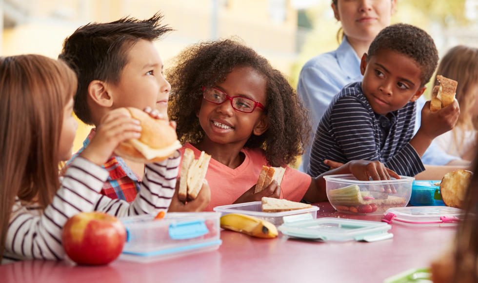 A group of young children sitting at a table eating