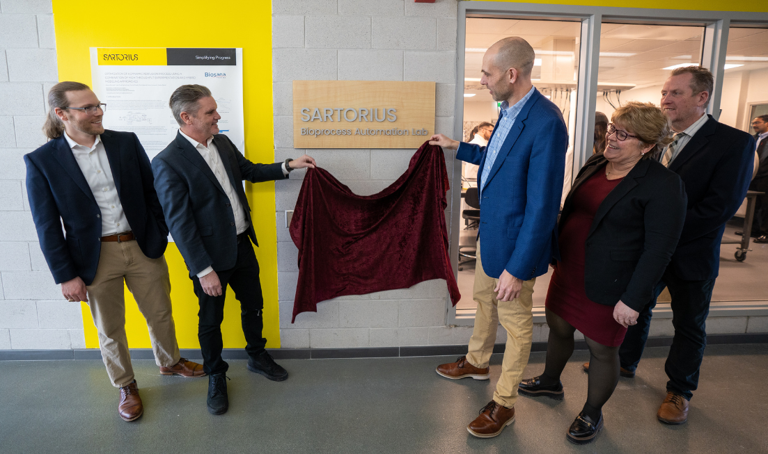 Two people unveil a plaque that reads "Sartorius Bioprocess Automation Lab", watched by 3 others.