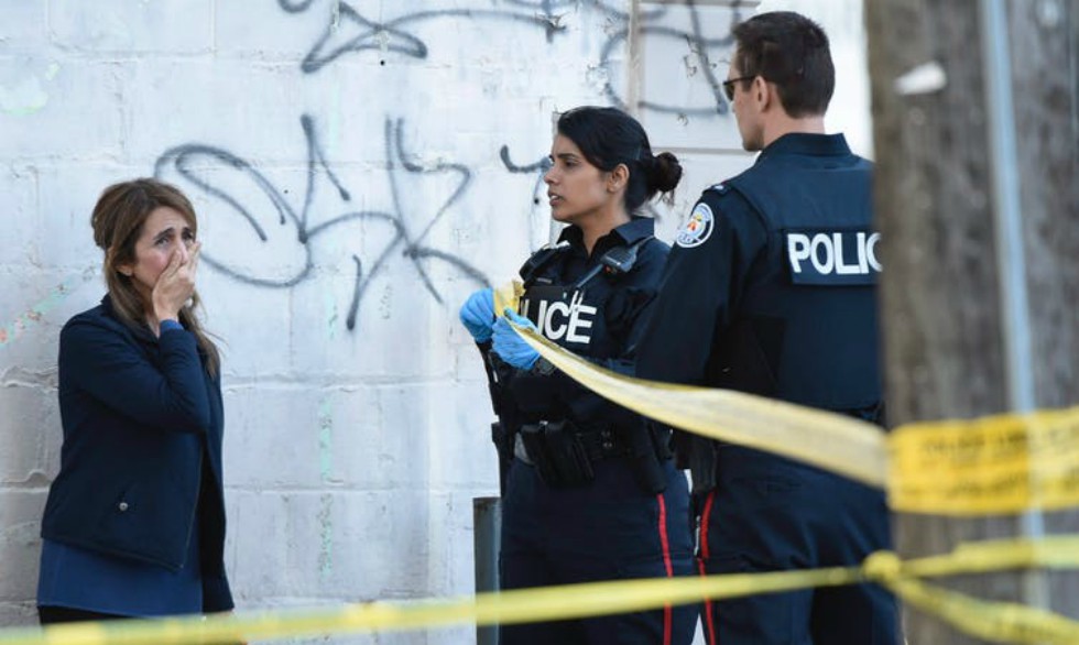 Toronto police talk to a woman after a van crashed into a number of pedestrians in Toronto on April 23, 2018, killing 10 people.