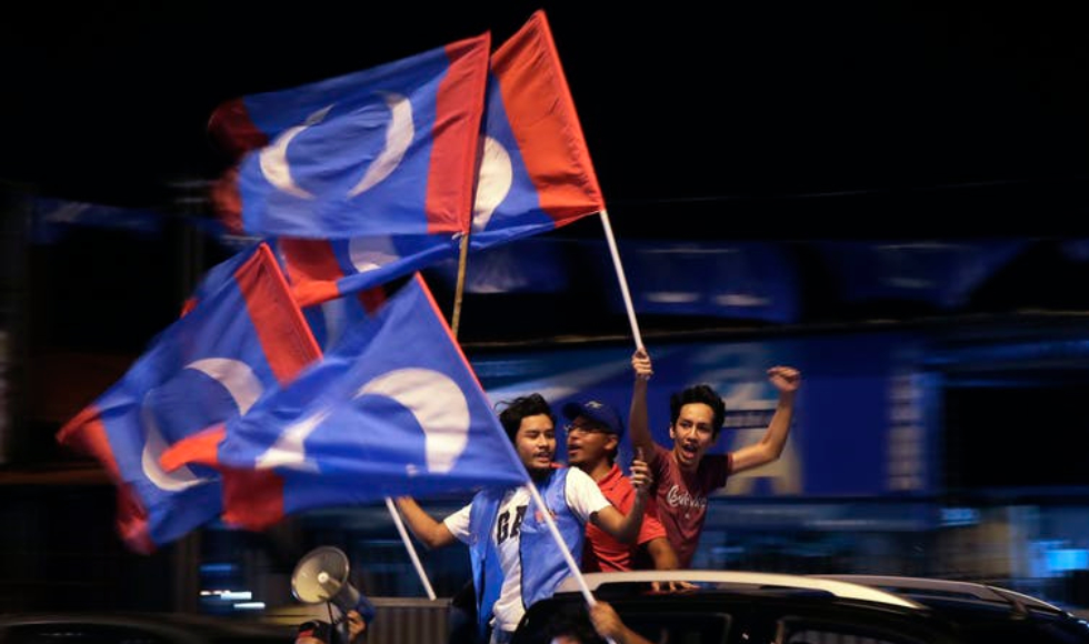 Supporters of Malaysia’s opposition coalition party hold party flags in northern Malaysia on the eve of the country’s recent election. Corruption-plagued Najib Razak was voted out while Mahathir Mohamad won. (AP Photo/Andy Wong)