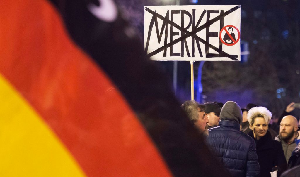 In this February 2016 photo, people wave German flags in Erfurt, central Germany, during a demonstration initiated by the Alternative for Germany (AfD) party. File photo by Jens Meyer/AP