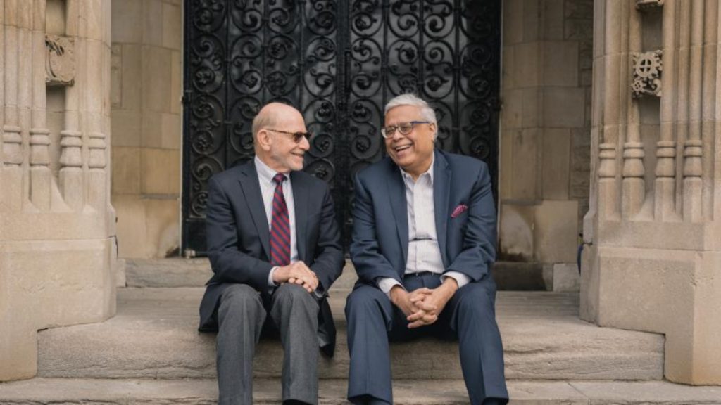 DeGroote School of Business Dean Len Waverman and Faculty of Engineering Dean Ishwar Puri sitting beside each other, smiling.