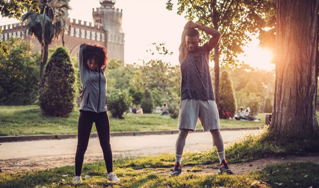 Two people stretching outdoors