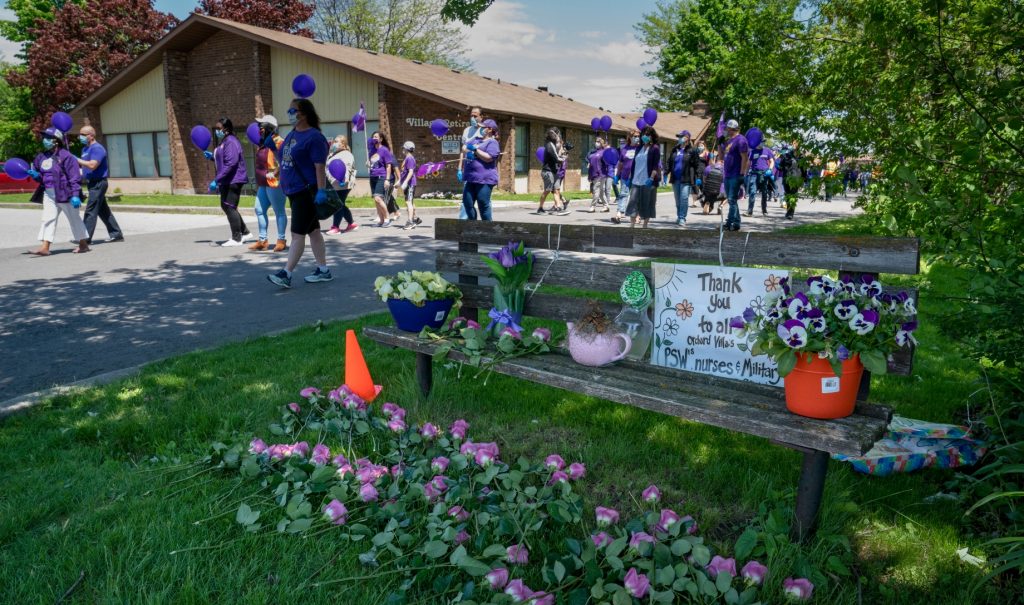 People march in support of nursing union members outside a retirement home.