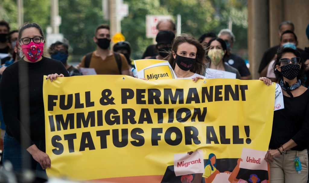 Protesters carry a big banner between them that reads 