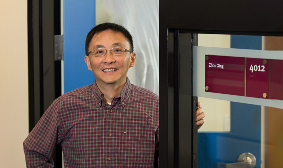 Zhou Xing standing in the doorway of his office.