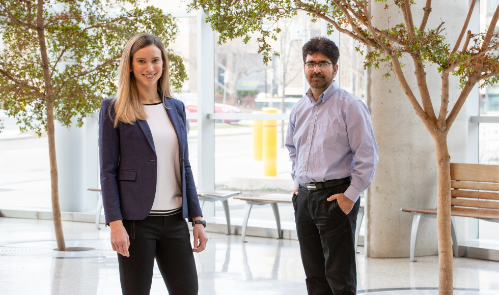 McMaster University researchers Ali Ashkar and Sophie Poznanski stand in an atrium.