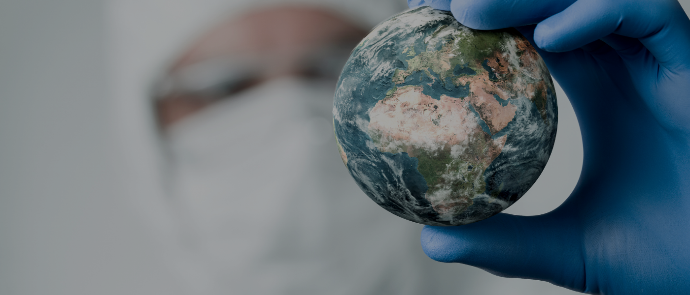 person in a mask holding up the globe