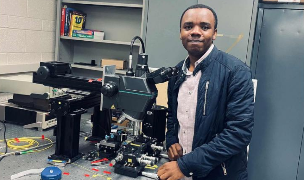 A Black student at a table full of equipment