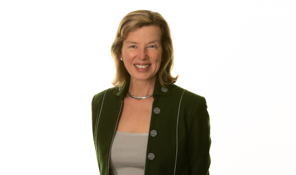 Smiling professor wearing a green jacket with buttons