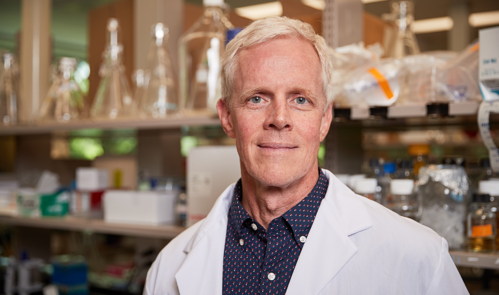 Eric Brown wearing a lab coat and looking at the camera