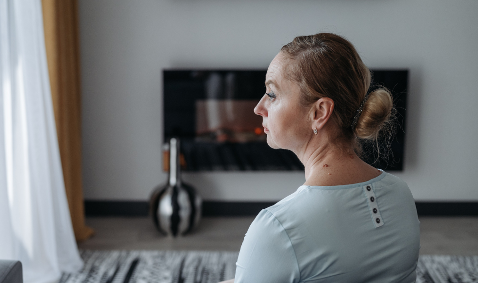 A woman sitting on a couch staring into the distance