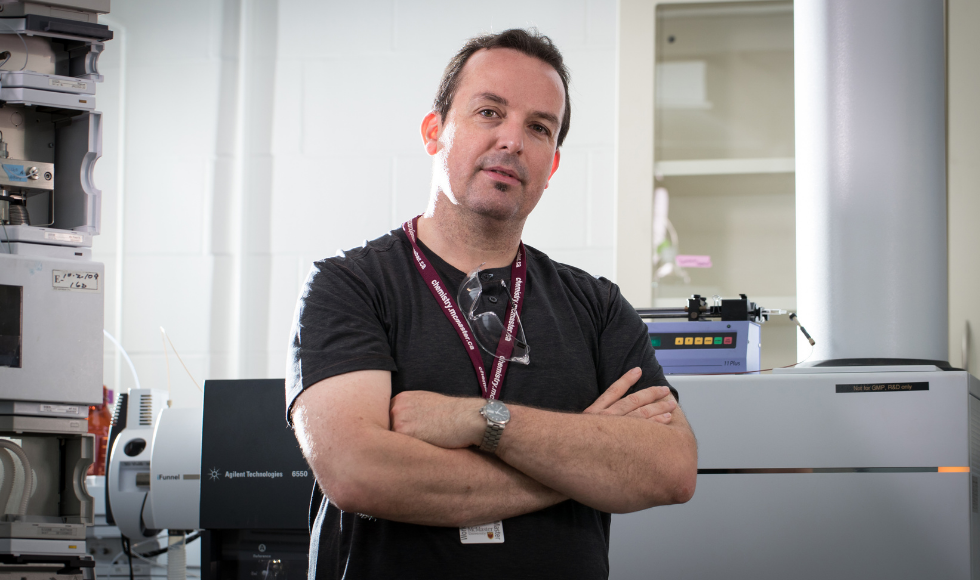 Philip Britz-McKibbin standing in a lab with his arms crossed looking directly at the camera.