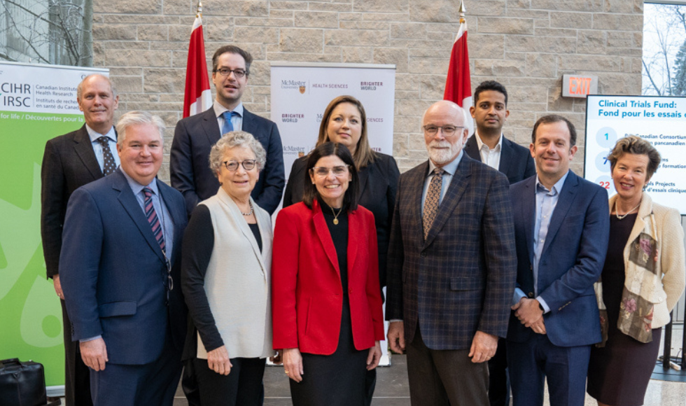 A group photo of seven researchers, university president David Farrar, MP Filomena Tassi and CIHR president Strong.