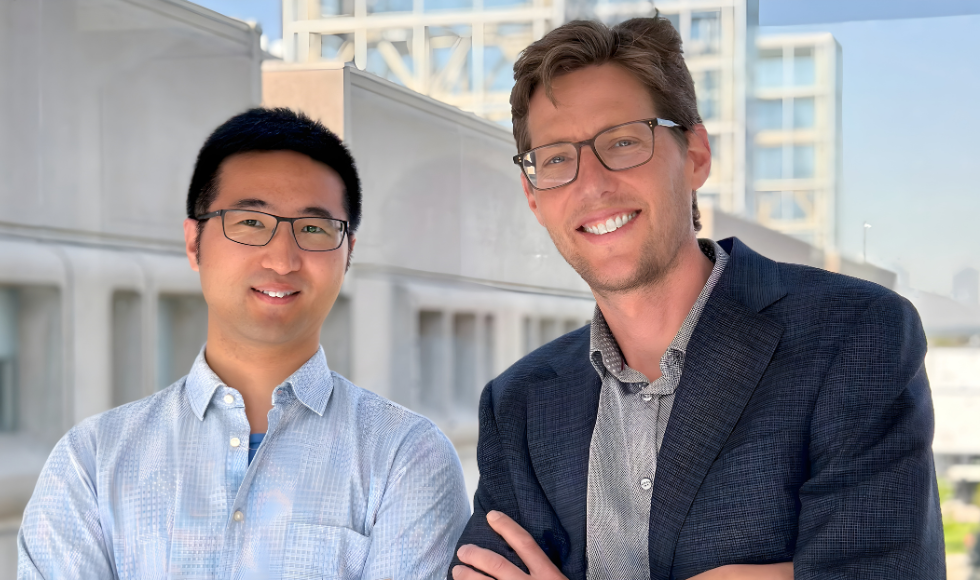 Dongdong Wang and Greg Steinberg head and shoulders photo taken outdoors, smiling.