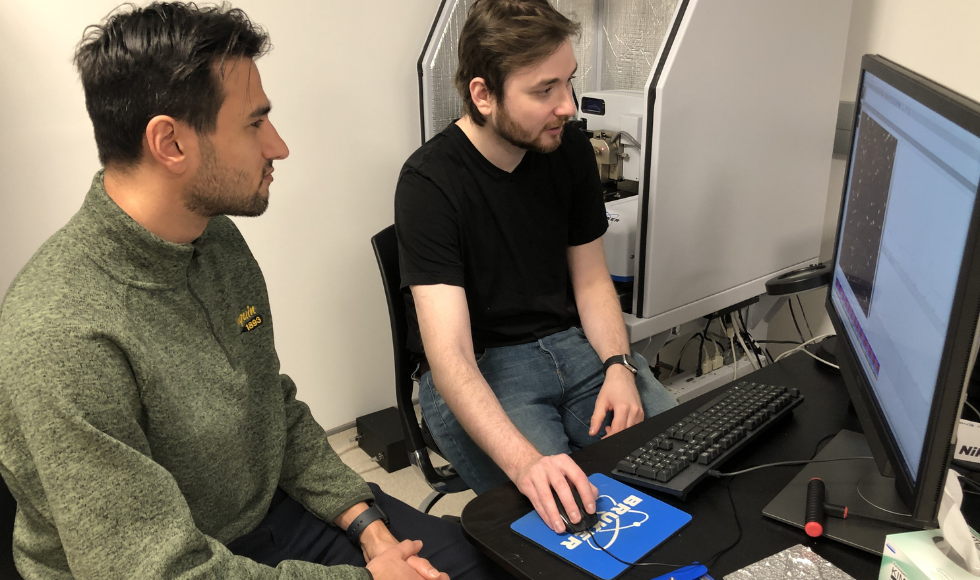 Image of two people looking at a computer screen