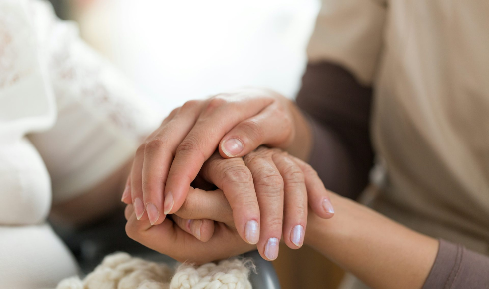 Two people's hands cupped around each other.