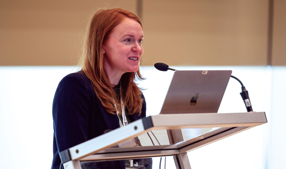 Head and shoulders of Caitlin Mullarkey speaking at a podium