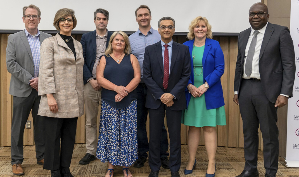 A group of leaders from the two universities standing and smiling.