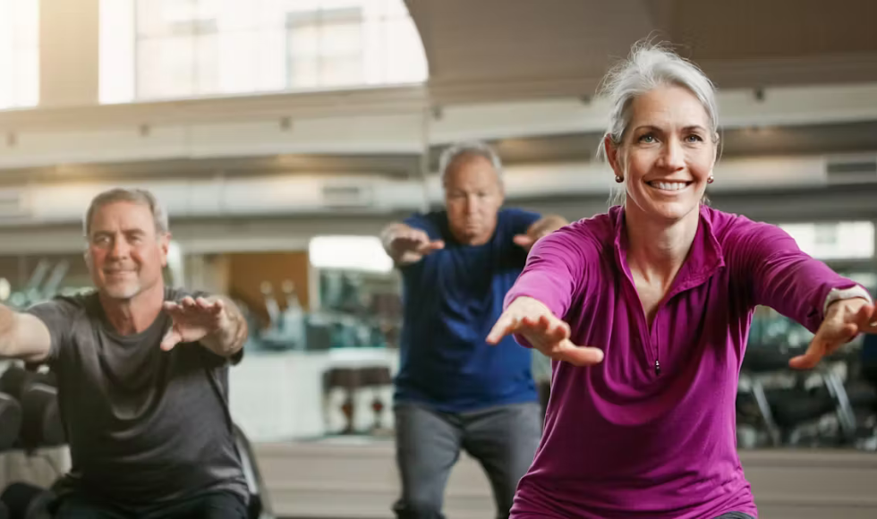 Three people, all with grey hair, exercising in a gym