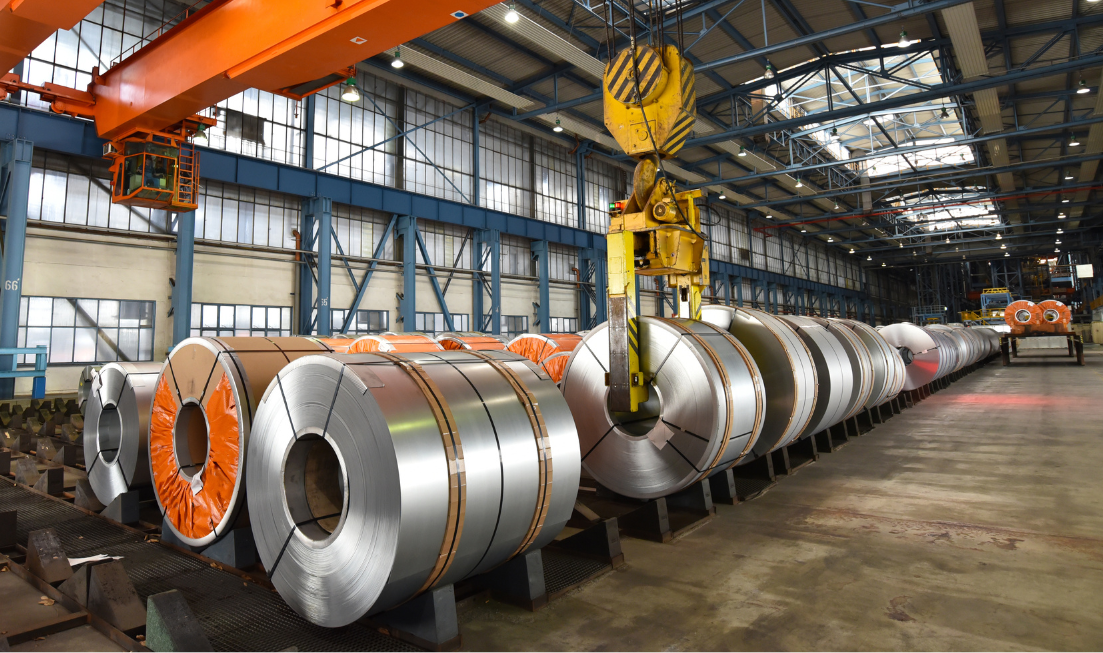 Rolls of steel in an industrial warehouse setting.